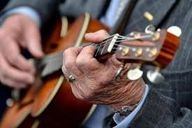 older man over 60 playing guitar part of a blog encouraging men over 60 to learn guitar