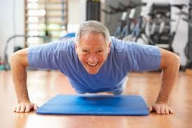 Senior man doing pushups in a gym as part of a strength training program for men over 60