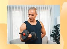 Senior man exercising with dumbbells at home as part of a strength training program for men over 60