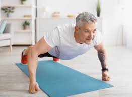 Older man over 60 performing doing pushups at home as part of a strength training routine