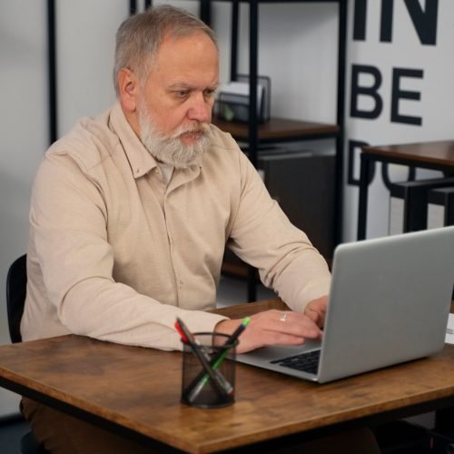 Older man on his computer learning affiliate marketing over 60